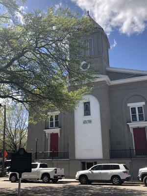 The front of the church with the red doors signifying a safe space and that the church's mortgage is "paid off".