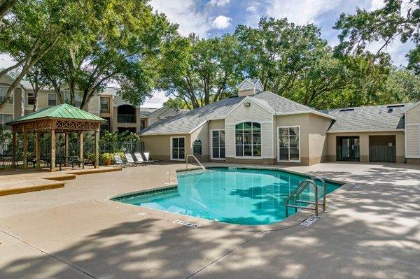 Swimming pool with lounge seating, shaded picnic seating, surrounded by native landscaping