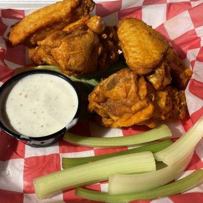 Buffalo wings with ranch dressing and celery sticks.