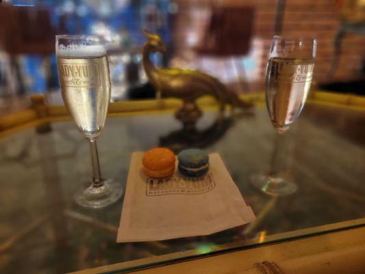 Two glasses of sparkling wine and two macarons