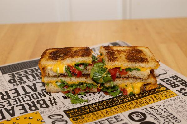 Cali Gold - Melty Cheddar and Pepper Jack with Roasted Red Bell Peppers and Arugula on Pesto Grilled Sourdough