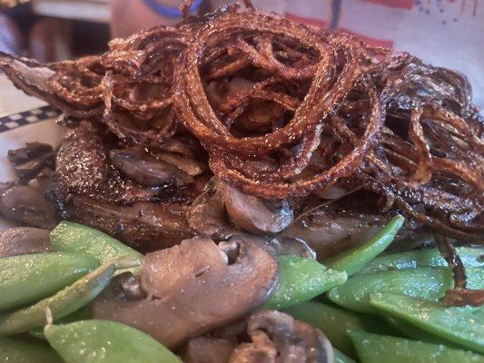 Big sky Rib eye with sautéed mushrooms and   Haystack fried onion strings.