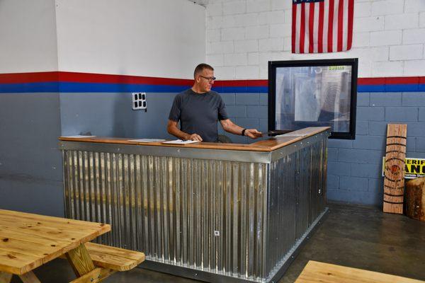 Tom Reese at the checkin counter that is just for Axe throwers