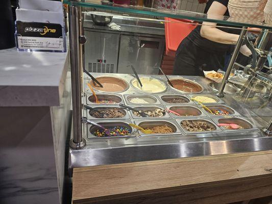 Zeppole toppings bar. She fills the zeppoles with fresh caramel from those pumps when they come out of oven.