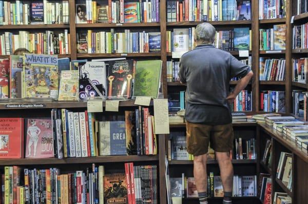 a snapshot of our comics section--in the background, a customer browses our fiction!