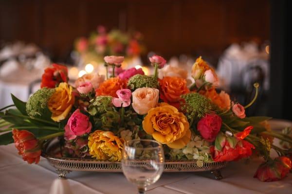 Beautiful mix of garden roses, ranunculus, peonies, hydrangea and other stems presented in a loose style on a silver platter.