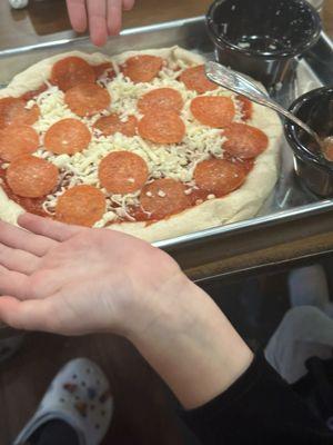 Children have fun creating their own pizza