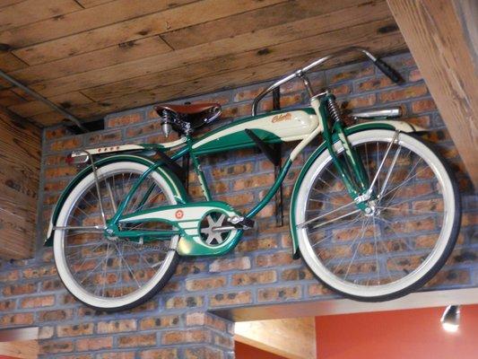 The owner collects old bikes. This is one hanging on the wall.