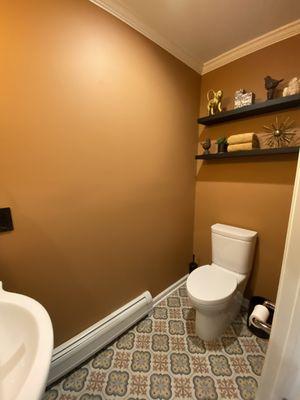 Tuscan inspired powder room with patterned porcelain tile floor.