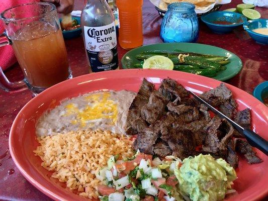 Carne asada accompanied by a Corona Michelada