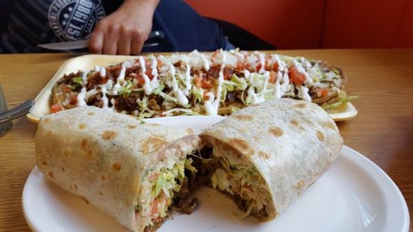 Steak burrito filled with beans lettuce tomotoe cheese and sour cream