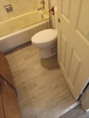 New subfloor, new toilet, and new vinyl flooring installation.