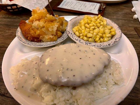 Fried chicken breast over rice with gravy with corn and peach cobbler