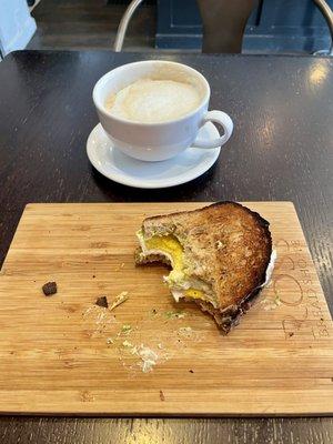 Avocado toast with egg added and a cappuccino