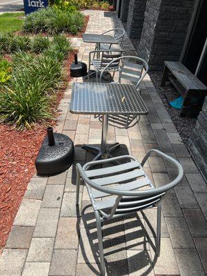 Two metal tables with no cover from the sun. The air conditioning units above them drip water on top of you.