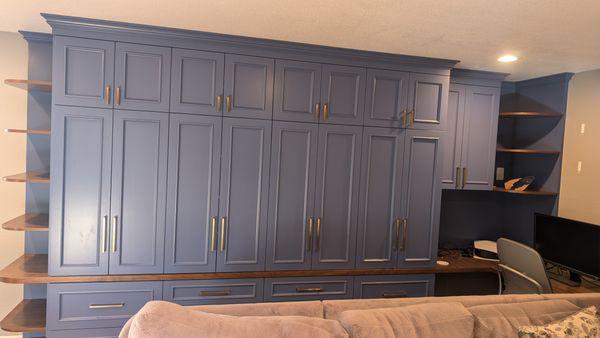 Custom cabinets with wrap-around built-in desk and adjustable corner shelves [front view]