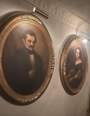 Oil portraits of Señor and Señora Maese (owners of the home) in the Carlota Salon