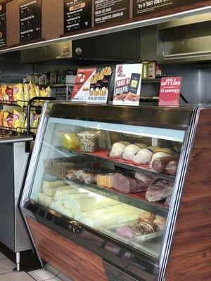 Display case of meats, cheeses & toppings used to create their subs