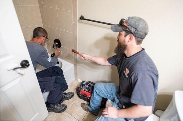 Alex and David repairing a shower faucet