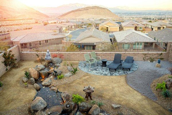 Stunning view of the Las Vegas sunset accenting the natural beauty of the backyard with various sculptures, water features and lounge area.