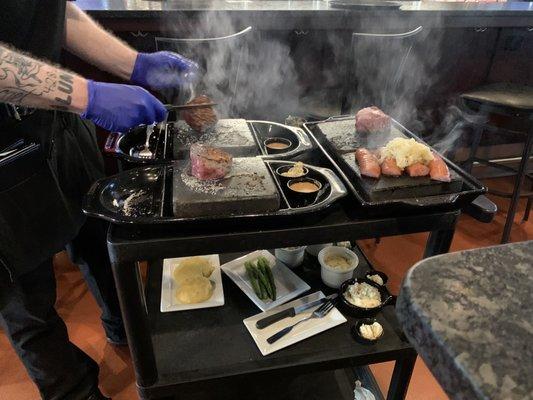 Waiter demonstrating how to cook the steak on the rocks