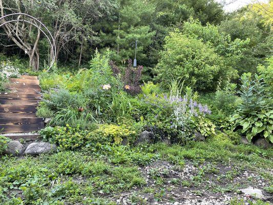 Before: a mess of rocks and 20 years of erosion had buried all but the top stone of the retaining wall. Grading ran water towards the house.