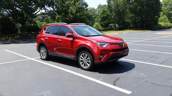 Detailing a red SUV in a parking lot