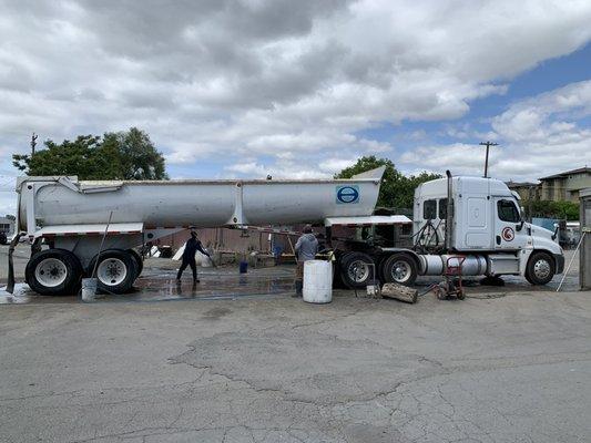 Giant trucks being washed by other crews