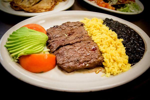 Carne Asada Steak at Flaco's- Served with fresh Haas avocado, black beans, and yellow rice