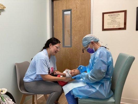 Mom, baby and Dr. Schwed doing lap exam at post frenectomy follow up appointment.