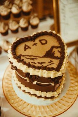 White chocolate cake w/ espresso mousse iced w/ chocolate buttercream. Used our monogram logo and edible gold.