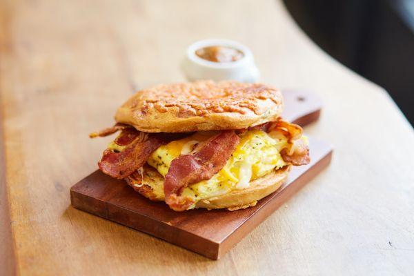 Bacon Bagel Sandwich with a side of salsa.