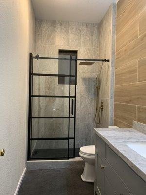 Hall bath with elongated niche and 5'x 1' wall tile behind the vanity.