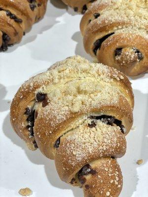 Concha Croissants filled with chocolate chips and topped with concha topping.