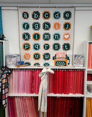 Sample of a cute quilt kit above red section of our color wall.