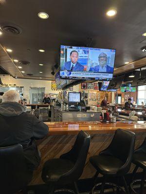 Large bar surrounded by big TV's