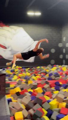 Flipping into one of many foam pits from a stationary elevated block