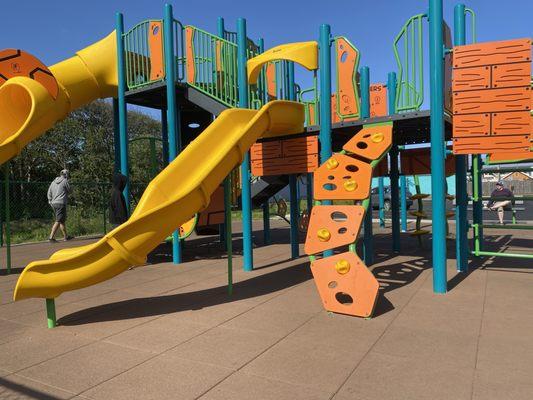 Large play structure with slides, climbing, music, monkey bars, hiding places