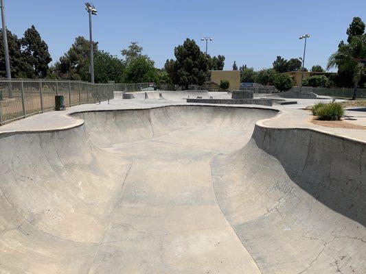 The skate park is empty on a Wednesday at 1 o'clock.