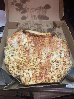 Uncut bent cheese pizza that was either flipped over or onto it's side.