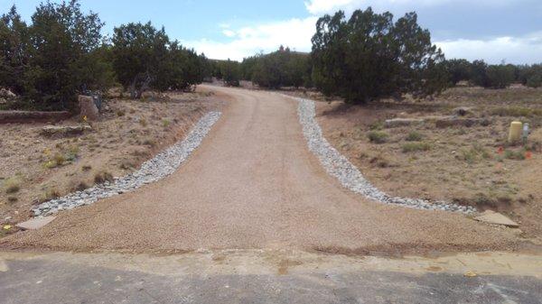 driveway re-do with rock lined ditches for drainage