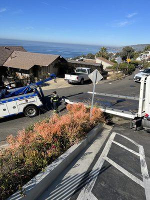 Tow truck blocking road making it impossible for me to get out of my street