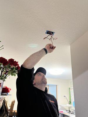 Harts Electrician installing a ceiling fixture.