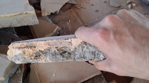 Thick layer of tile being removed by a Renegade Riding Floor Scraper