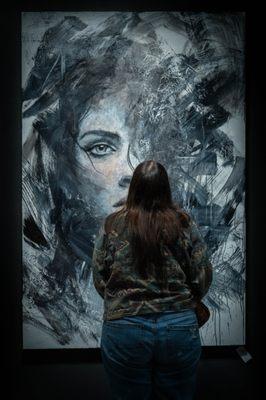 A viewer stands in front of Josh Hernandez's painting