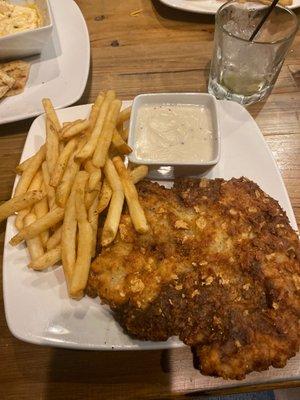 Chicken fried steak with gravy on the side.