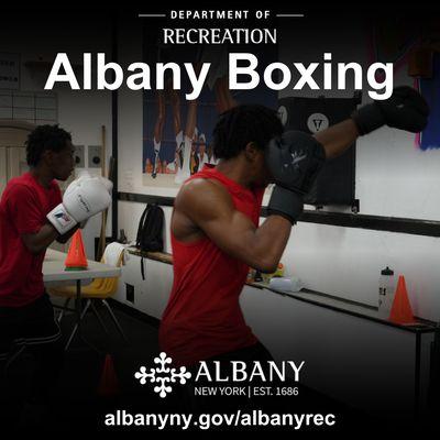 Participants are practicing on wall punching bags as directed by experienced coaches.