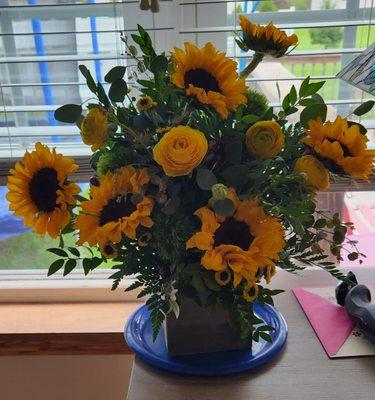 Huge sunflowers and yellow roses accompanied by greenery and berries! Gorgeous!