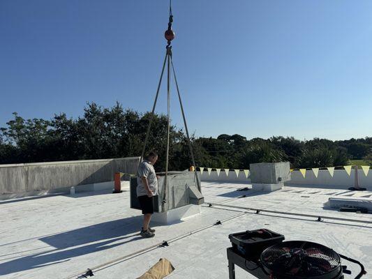 Bradenton Building Services HVAC Technician Removing Old System With Crane Assist.