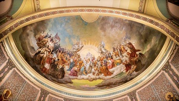 The mural above the sanctuary is named "The Triumph of the Risen Lord". It depicts Saints from the Old Testament and the New Testament.